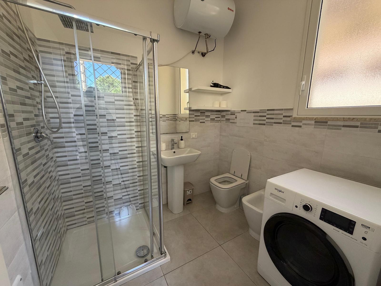 Bagno con box doccia e lavatrice